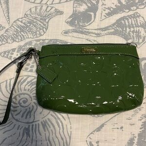 Coach wristlet in green. 7”x5” it has one. Small slip in pocket the inside